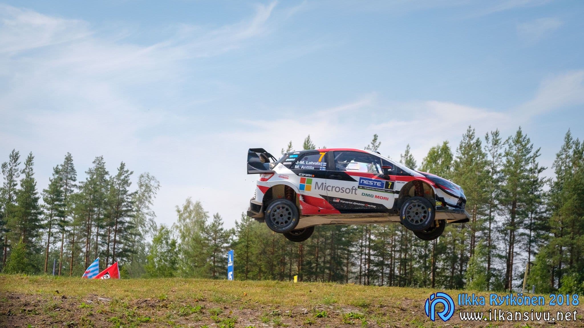 Jari-Matti Latvala ja Miikka Anttila, Toyota Yaris WRC numero 7, hypyn aikana mäntymetsän edustalla – Neste Rally Finland 2018