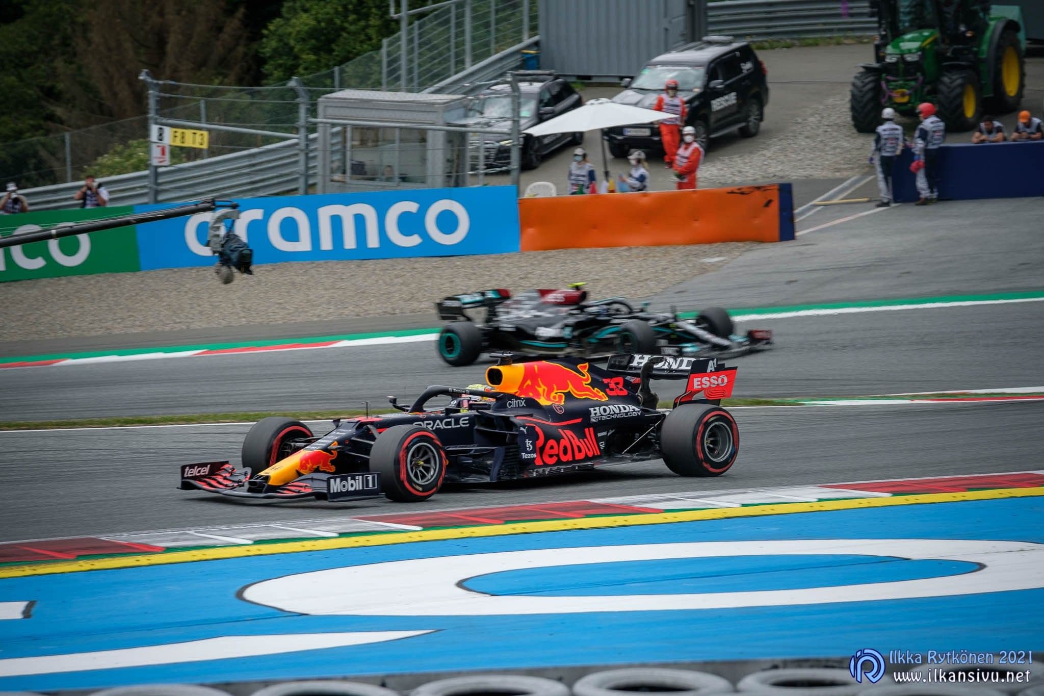 Red Bull- ja Mercedes-formula-autot radan mutkassa.