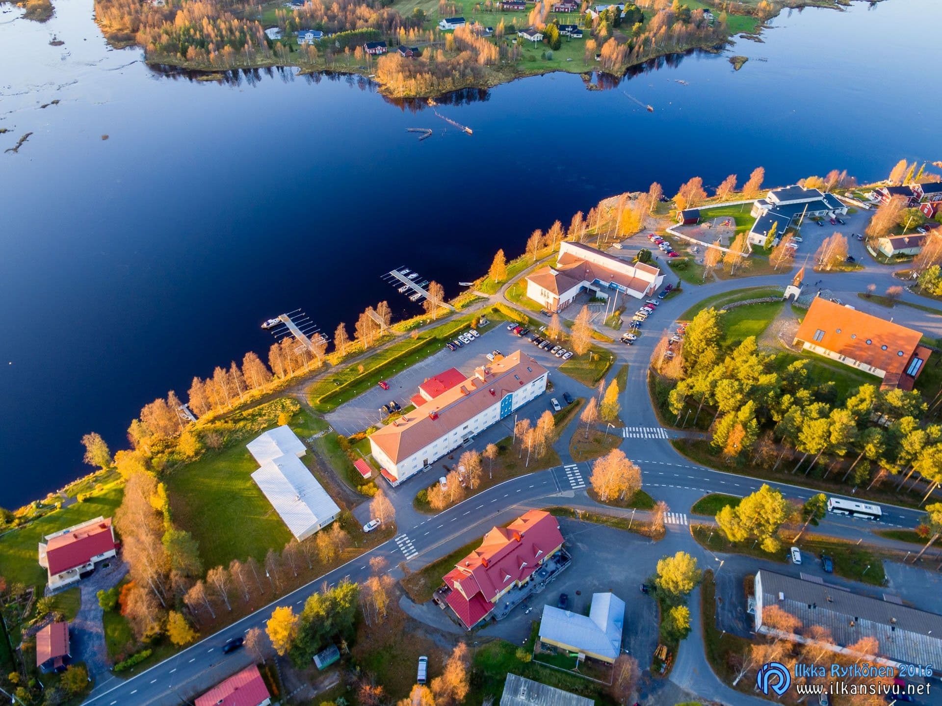 Aerial view of a waterside village and yellow autumn trees