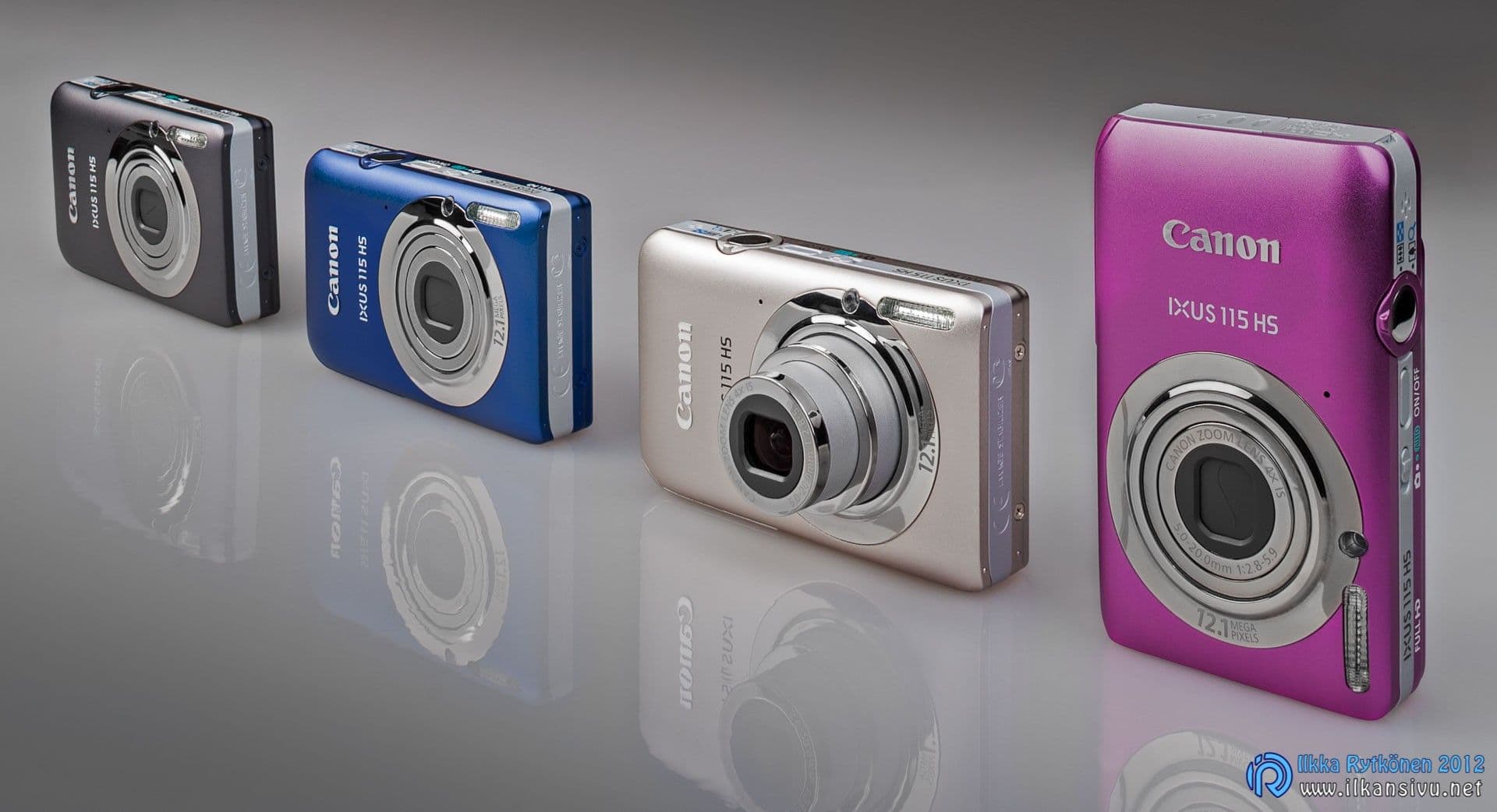 Four compact cameras arranged on a reflective surface with a wide depth of field